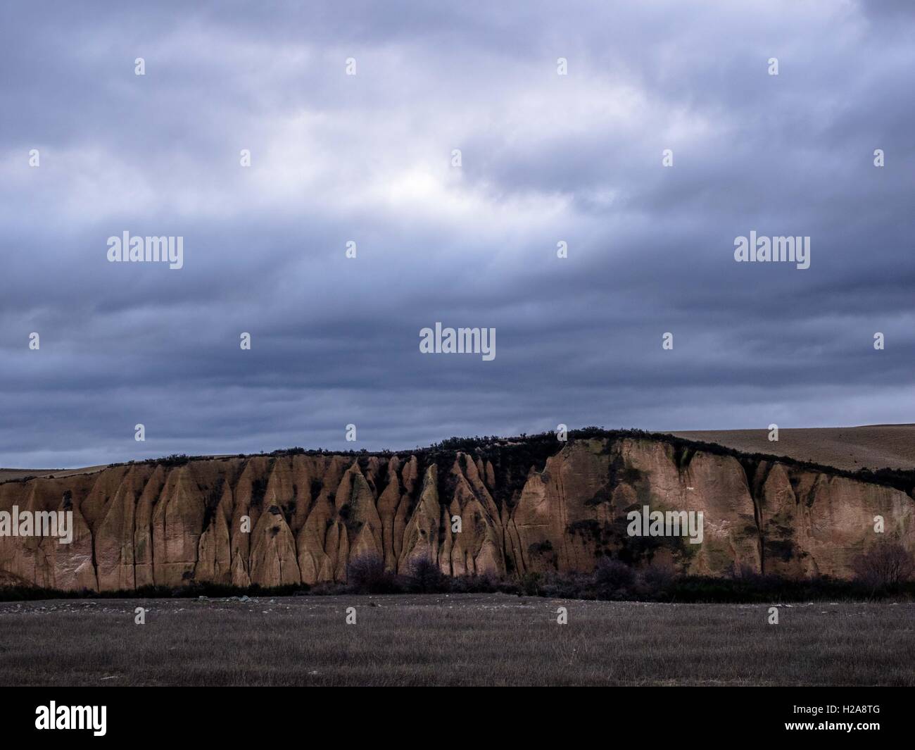 Il tramonto guardando sopra i campi grigi verso sluiced cliff un rotolamento big sky oltre kyeburn scavi, storico campo oro Maniototo nz Foto Stock
