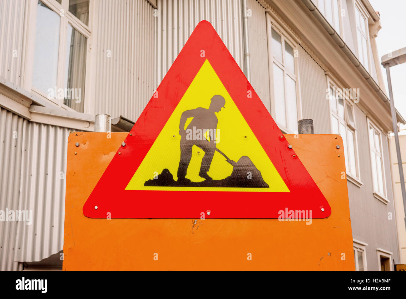 Sotto il segno della costruzione di una strada con edifici Foto Stock