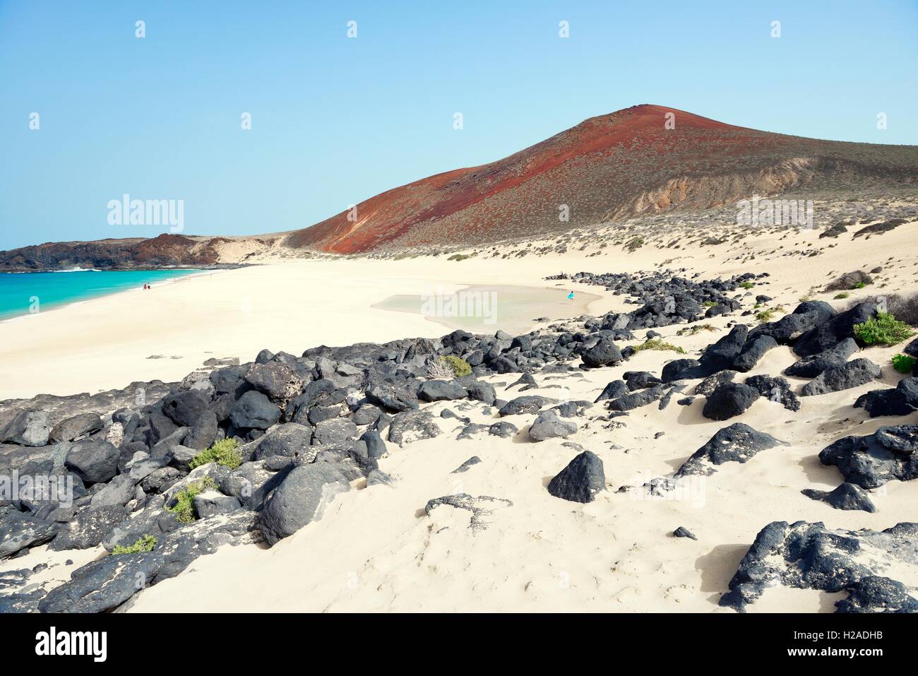 Lanzarote, Isole Canarie. Lungo la spiaggia di Playa de las Conchas su Isla Graciosa, Lanzarote, a cono vulcanico del Montana Bermeja Foto Stock