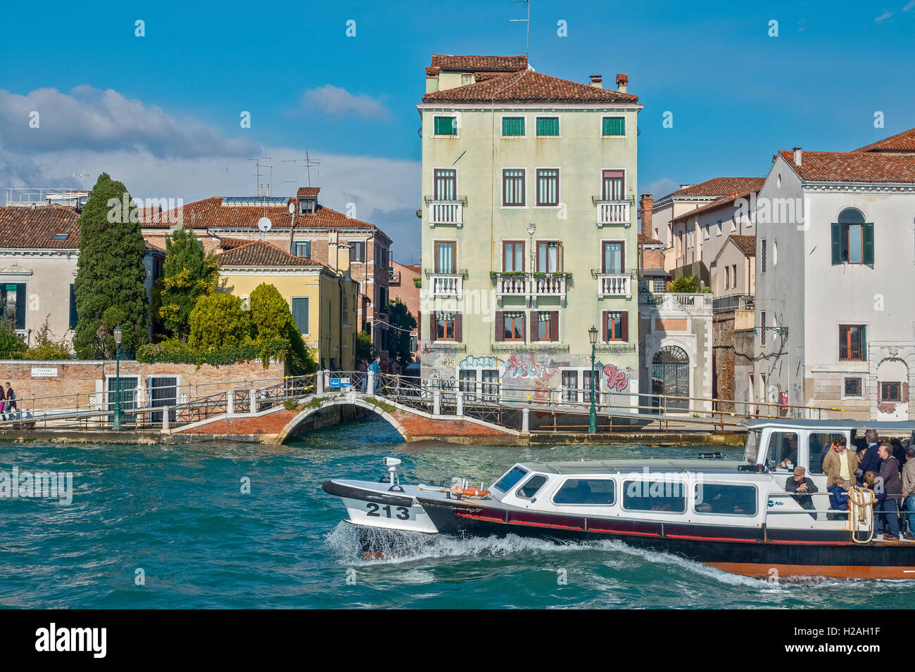 Barca passando un ponte sul Canal Venezia Italia Foto Stock