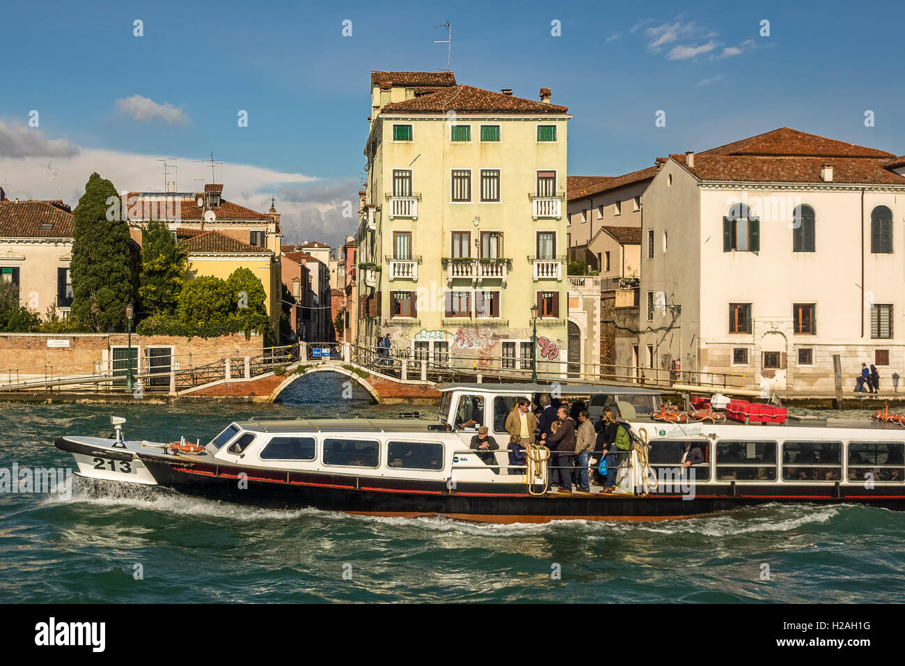 Barca passando un ponte sul Canal Venezia Italia Foto Stock