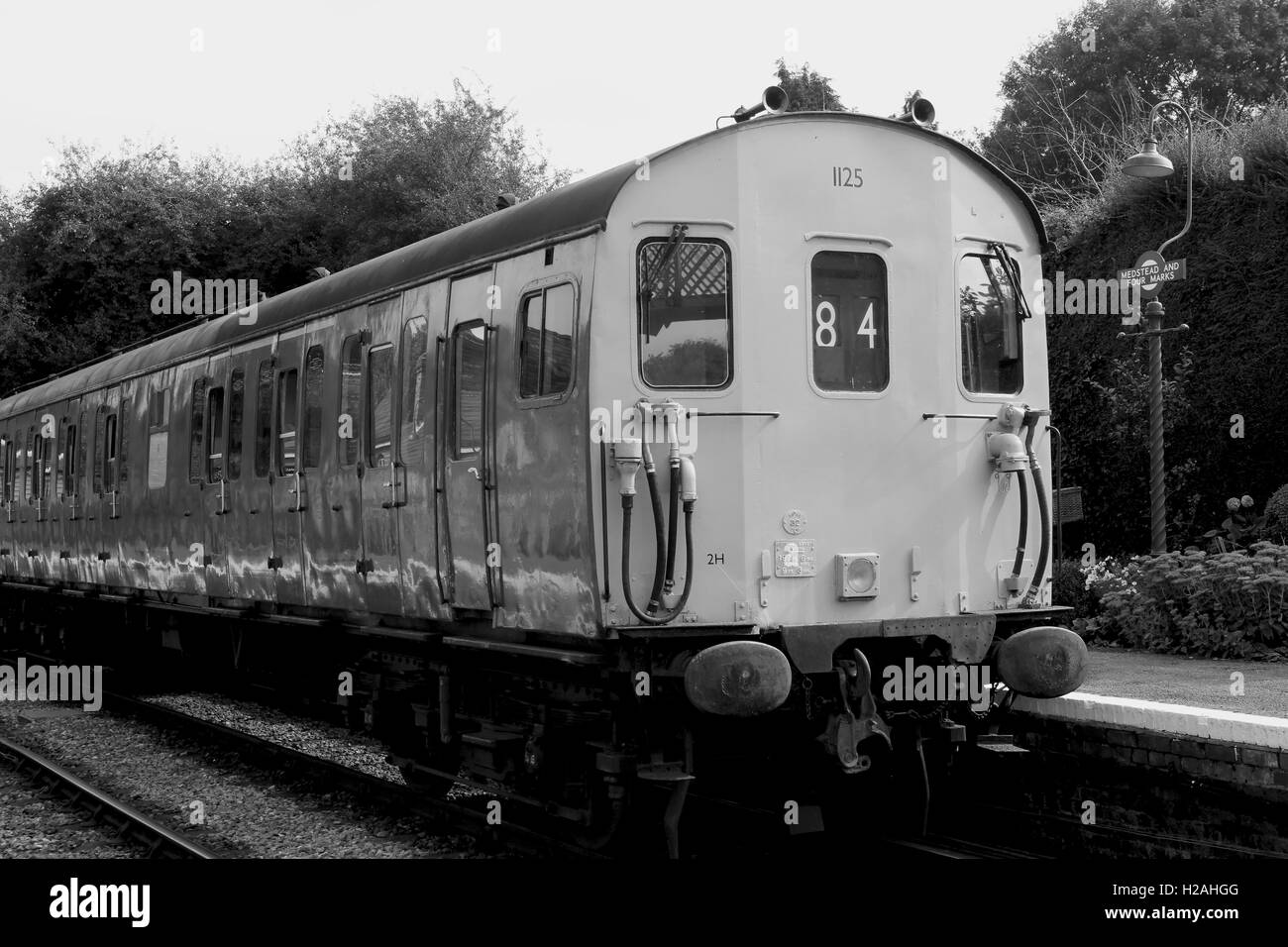 Vecchio treno diesel in corrispondenza di una stazione piattaforma. Girato in bianco e nero per dare il look retrò per un vintage modalità di trasporto Foto Stock