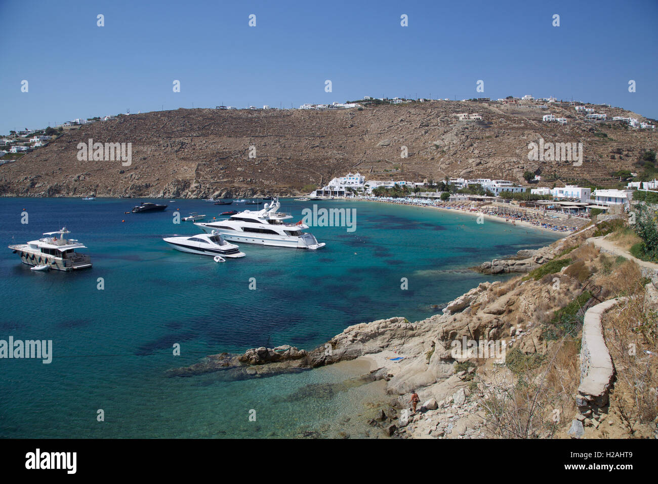 Psarou Beach Bay Mykonos Isola Grecia con l'azzurro del cielo e del mare yachts dalla scogliera con yachts Foto Stock
