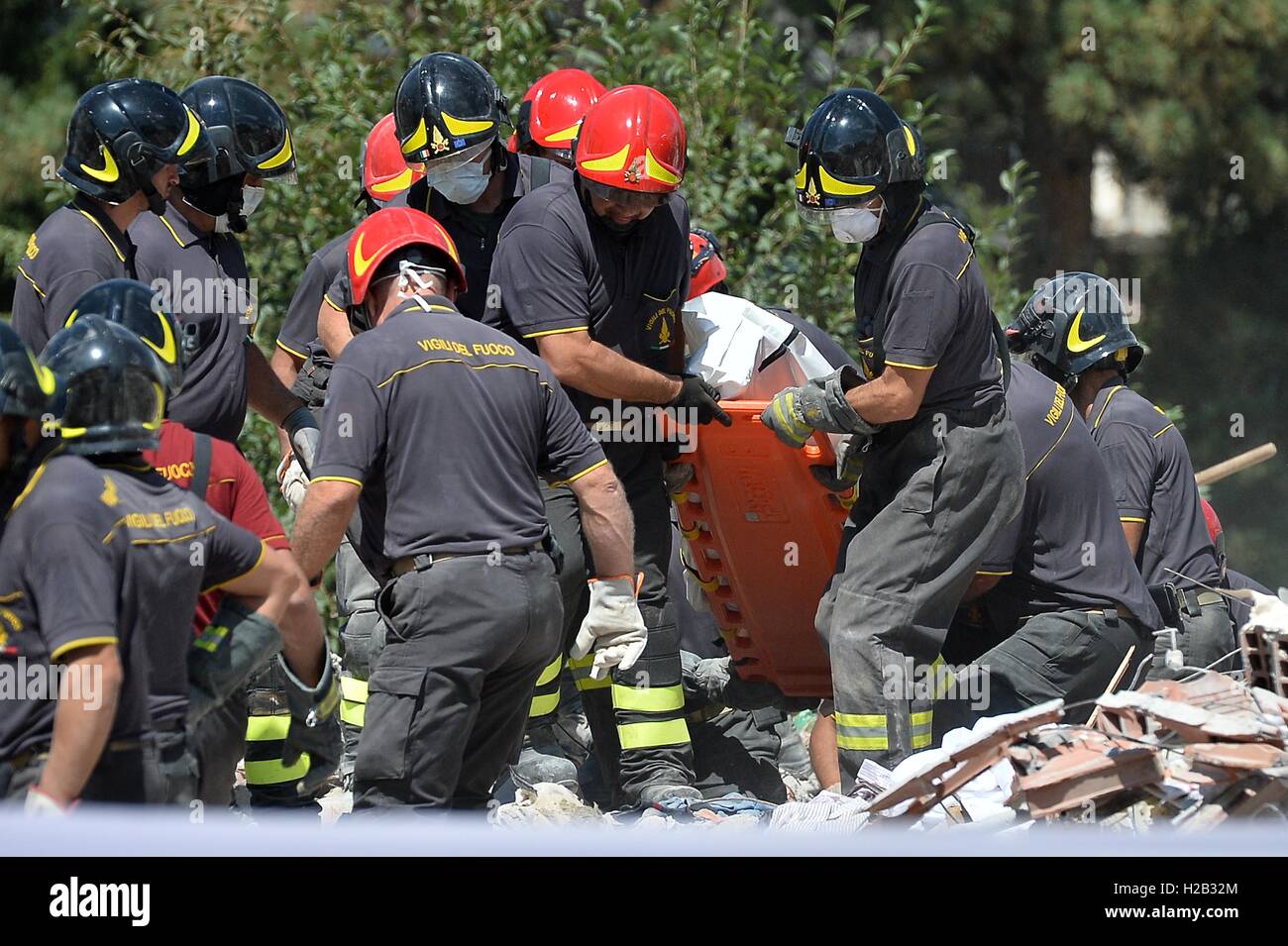 Lavoratori di emergenza continua la ricerca di vittime in edifici danneggiati ad Amatrice, Italia. Persone impostare le tende in un parco dopo essere state colpite dal terremoto. Il numero di morti in 6.2 grandezza terremoto che colpì intorno alla regione Umbria di Ita Foto Stock