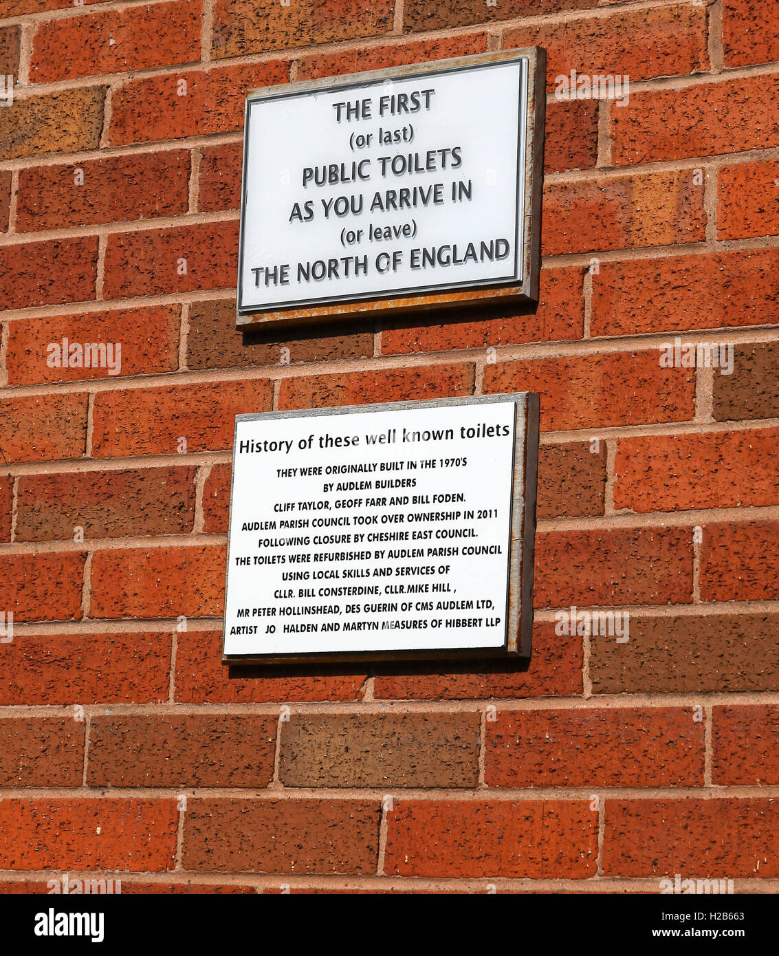 Le placche su un muro di mattoni che dice che il primo e ultimo tolette nel nord dell'Inghilterra nel villaggio di Audlem Cheshire England Regno Unito Foto Stock