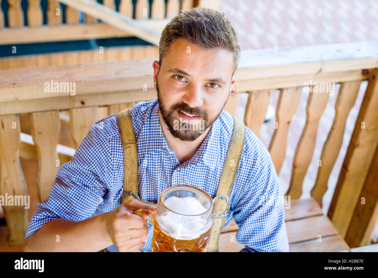 Uomo in tradizionali abiti bavarese con birra e salatini Foto Stock