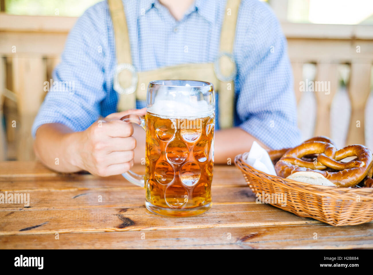 Uomo in tradizionali abiti bavarese con birra e salatini Foto Stock