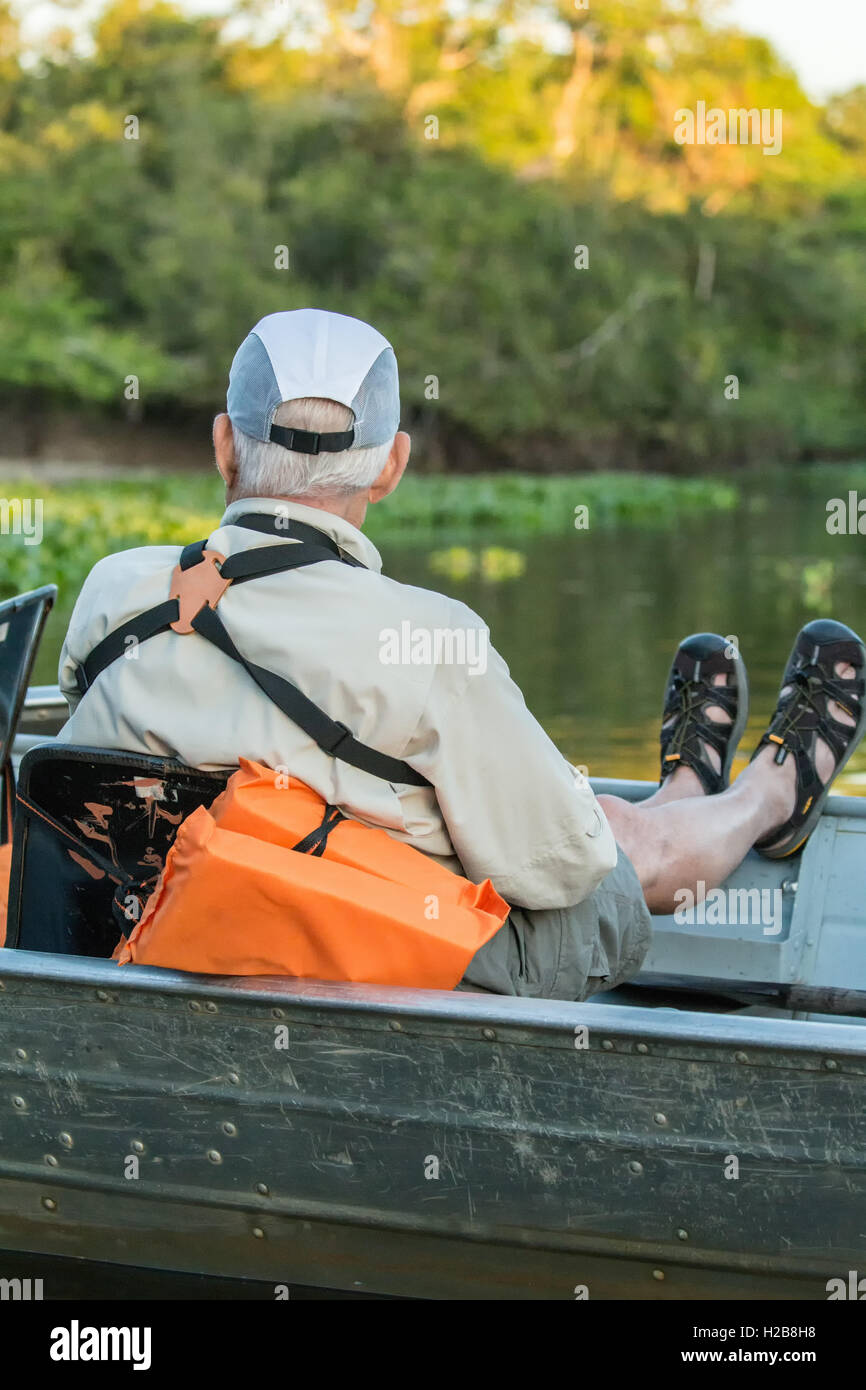 Maschio di turisti in un tour in barca in attesa di una Jaguar per spostare su un fiume safari nella zona Pantanal del Brasile. Foto Stock