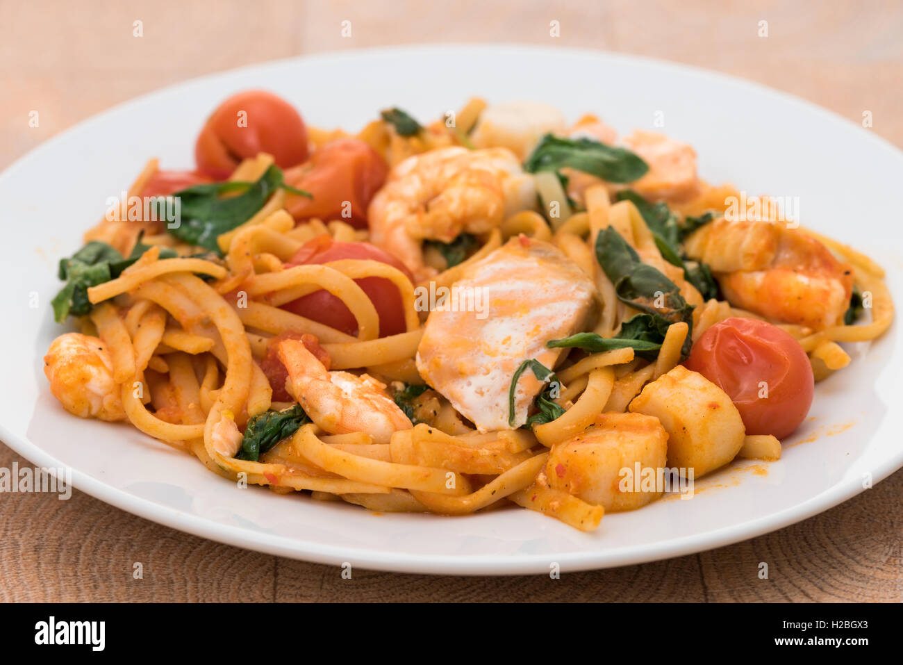 Frutti di mare linguine con gamberoni, capesante e salmone Foto Stock