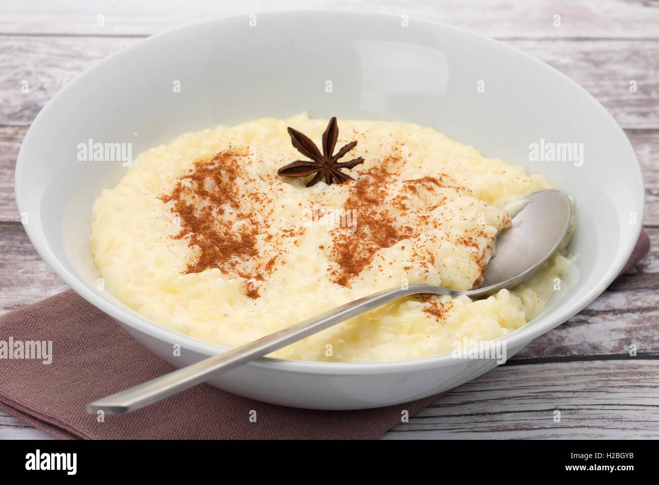 Una ciotola di crema di budino di riso che è stata spolverata di cannella in polvere. Foto Stock