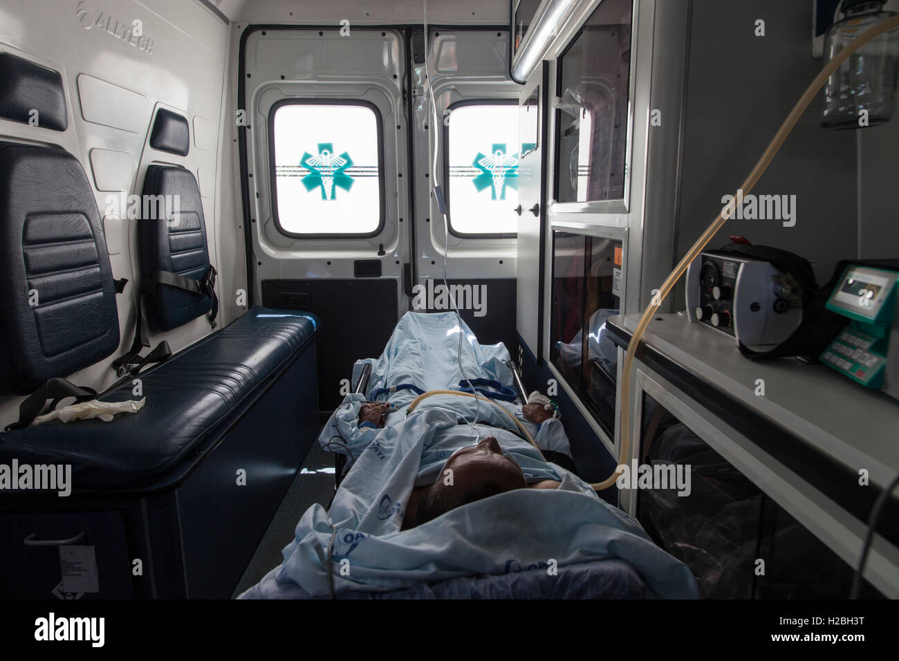 Paziente all'interno di un'ambulanza, un veicolo per il trasporto di feriti o ammalati gravi da, a o tra i luoghi del trattamento di una malattia o di lesioni, e in alcuni casi sarà anche fornire di ospedale di cure mediche per il paziente. Foto Stock