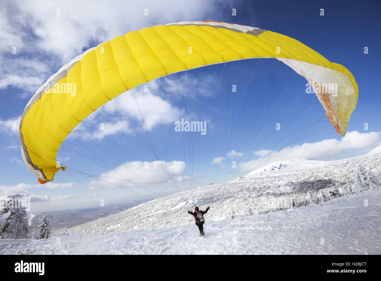 Parapendio inizia a volare dalla cima della montagna di neve Foto Stock