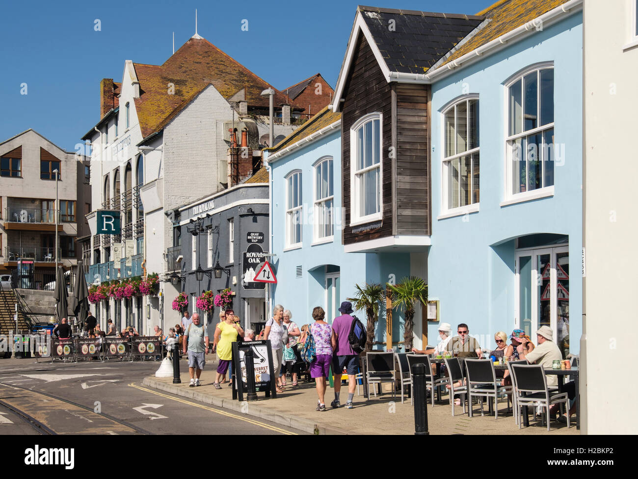 La gente che cena fuori dello Ship Inn e Royal Oak pub affollati nel sole di settembre. Custom House Quay, Weymouth, Dorset, Inghilterra, Regno Unito Foto Stock
