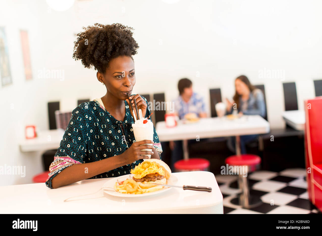 Giovane africano donna americana nel diner Foto Stock