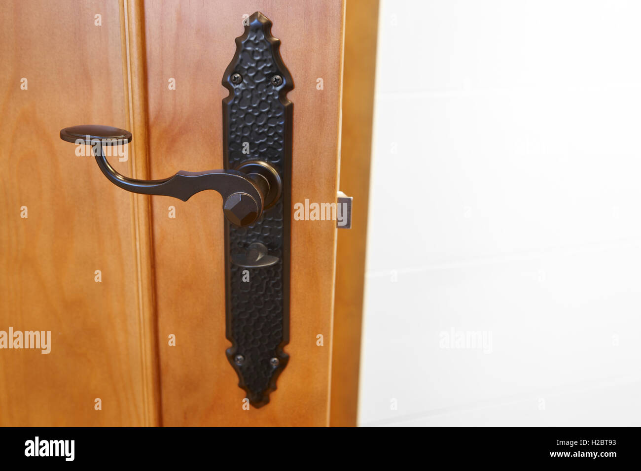 Classic maniglia della porta in una porta aperta e pareti bianche. Posizione orizzontale Foto Stock