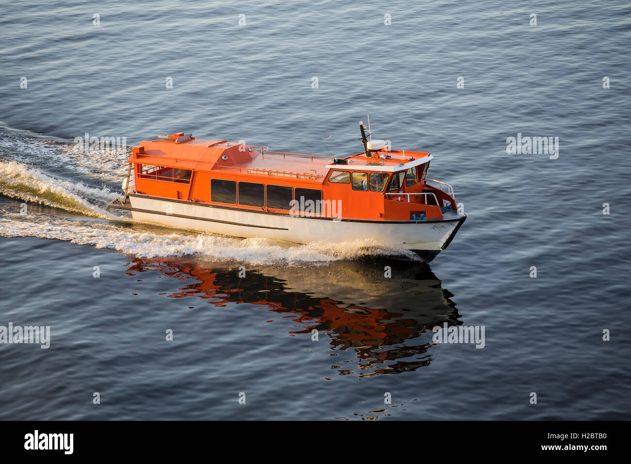 Una piccola barca di salvataggio accompagna l'oceano traghetto per navigare tra le isole Foto Stock