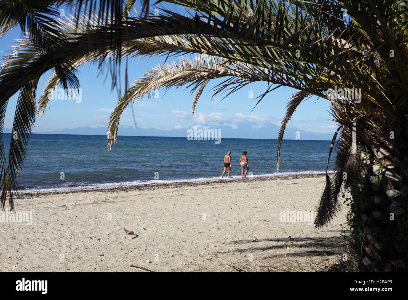 Un giovane a piedi lungo la spiaggia di Nea Moudania, Macedonia, Grecia Foto Stock