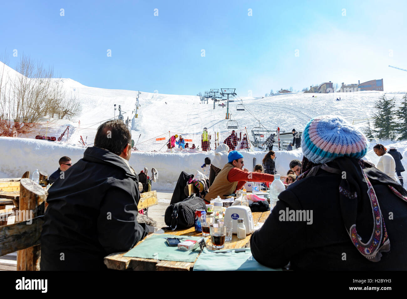 Persone che pranzano in una terrazza ristorante nella stazione sciistica di Mzaar Kfardebian, ex stazione sciistica di Faraya, Libano, inverno in Medio Oriente Foto Stock