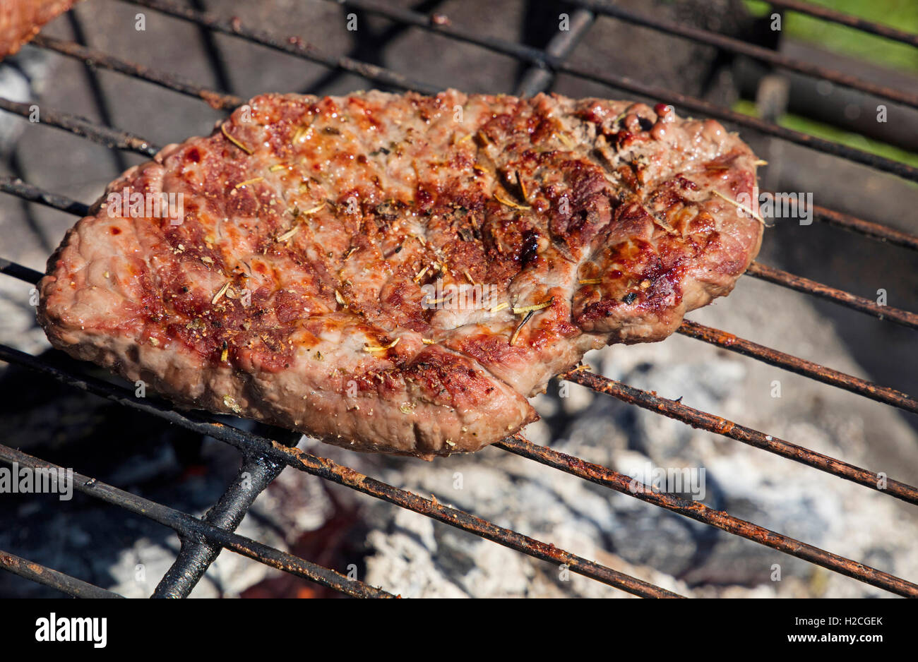 Una grigliata di carne di manzo barbecue preparato di cottura sulla griglia per il barbecue, close up Foto Stock