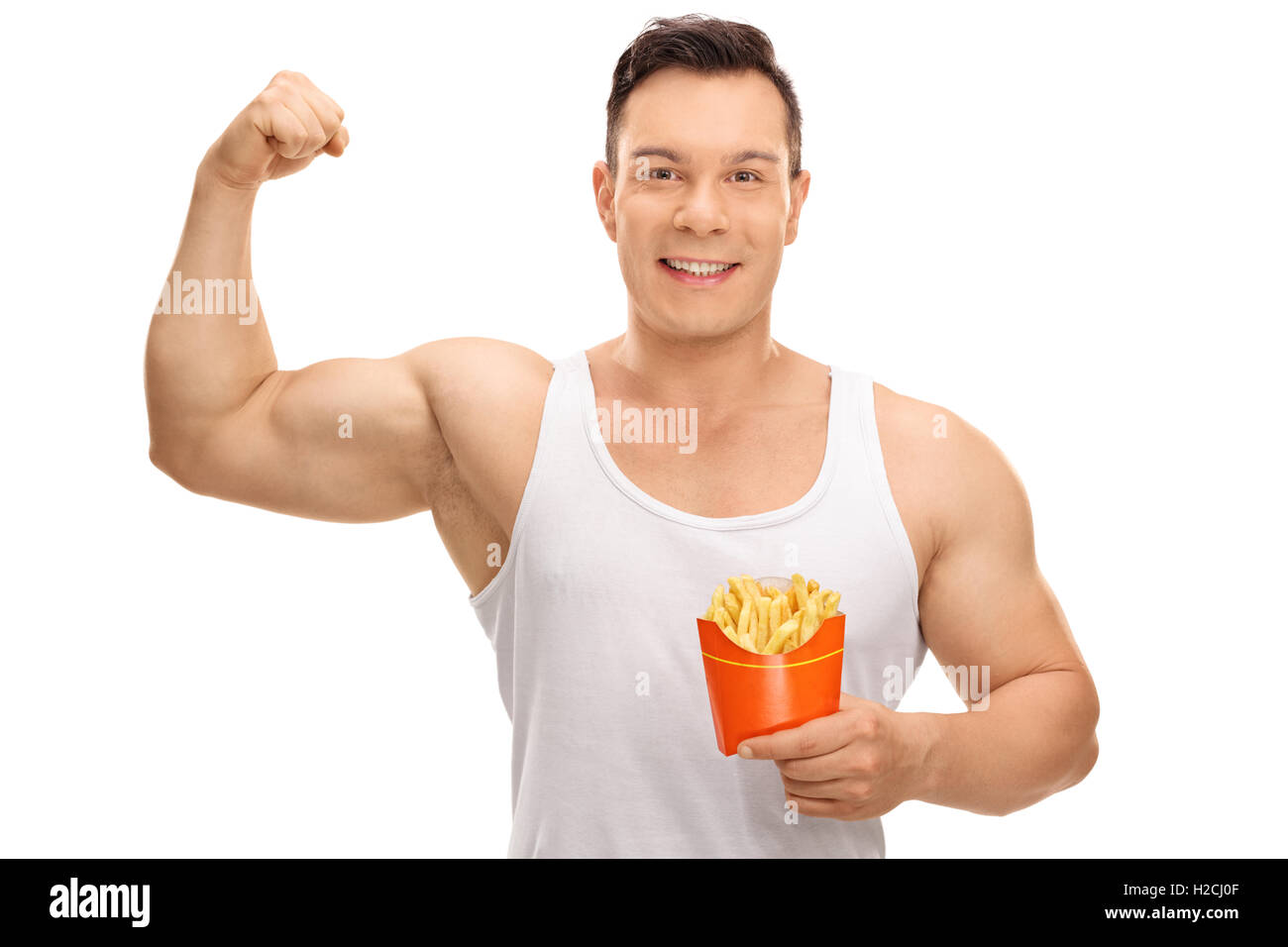 Allegro ragazzo flettendo il suo bicipite e tenendo un sacchetto di patatine fritte isolati su sfondo bianco Foto Stock