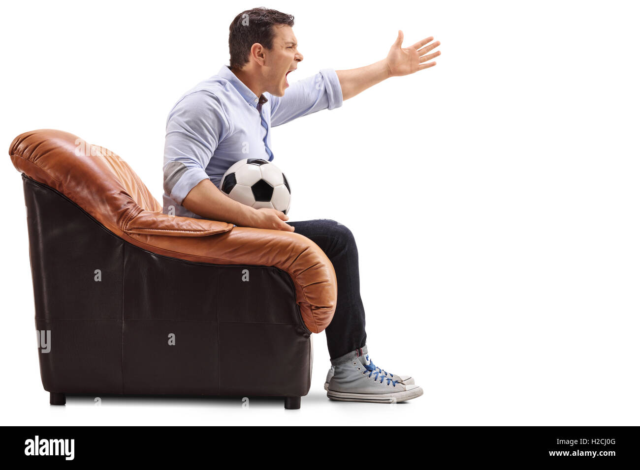 Infastiditi uomo seduto su una poltrona a guardare il calcio e urla isolati su sfondo bianco Foto Stock