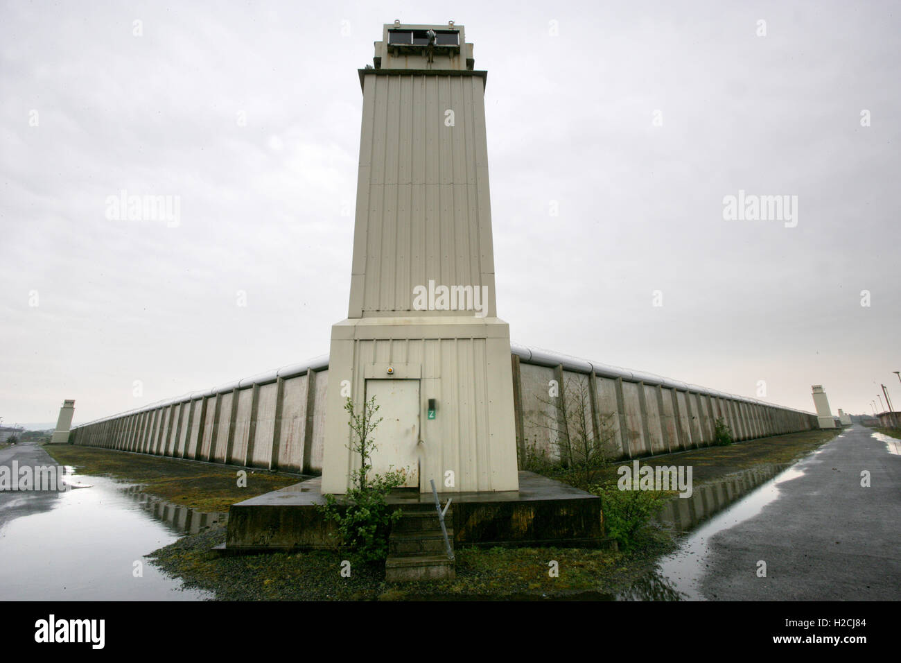 Una torre di avvistamento e parete perimetrale segna il confine dell'ex carcere di Maze, a ovest di Belfast in Irlanda del Nord, Regno Unito Foto Stock