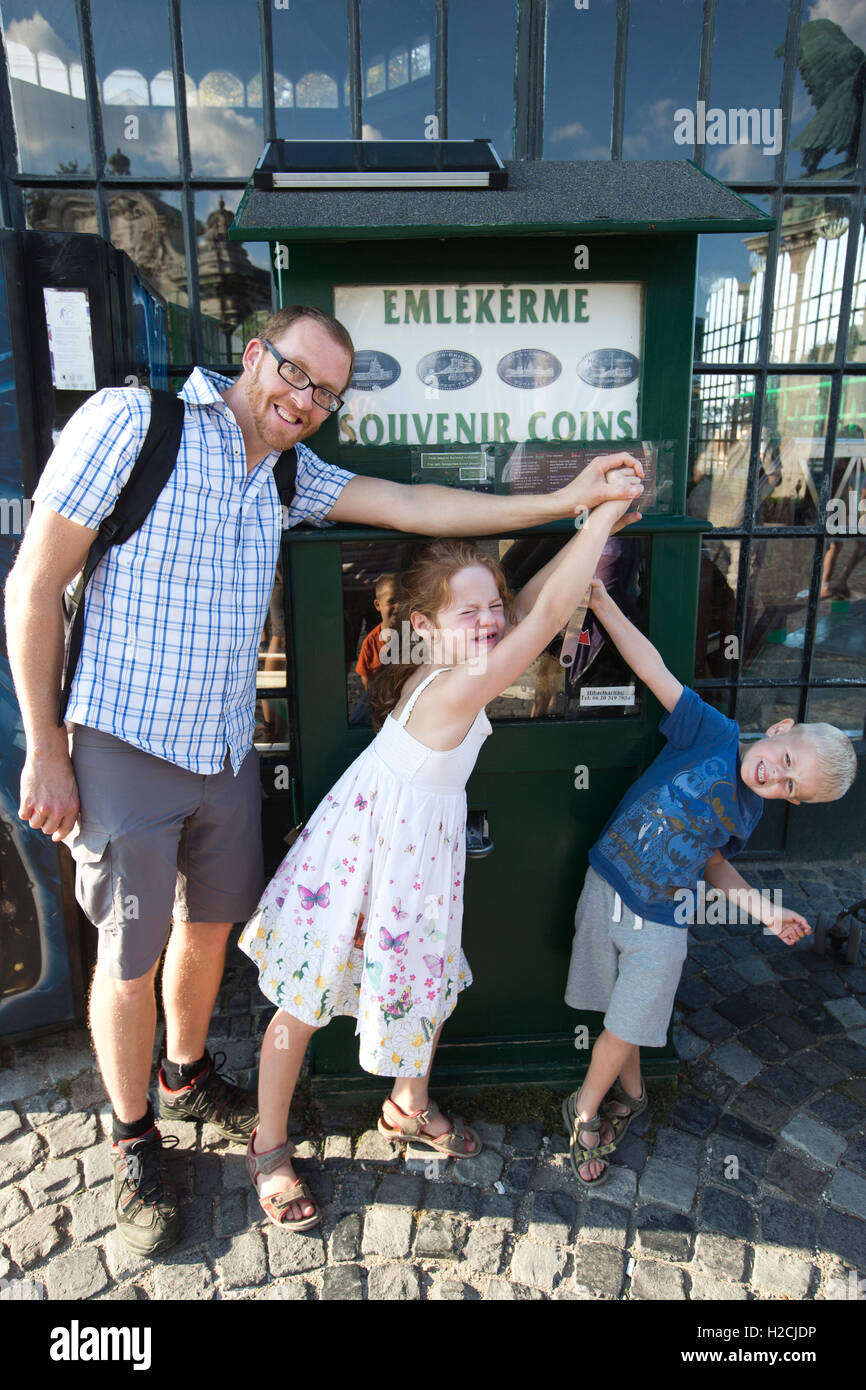 Famiglia rendendo le monete di souvenir al di fuori della Funicolare funivia terminus, Castello di Buda, Budapest, Ungheria, Europa Foto Stock