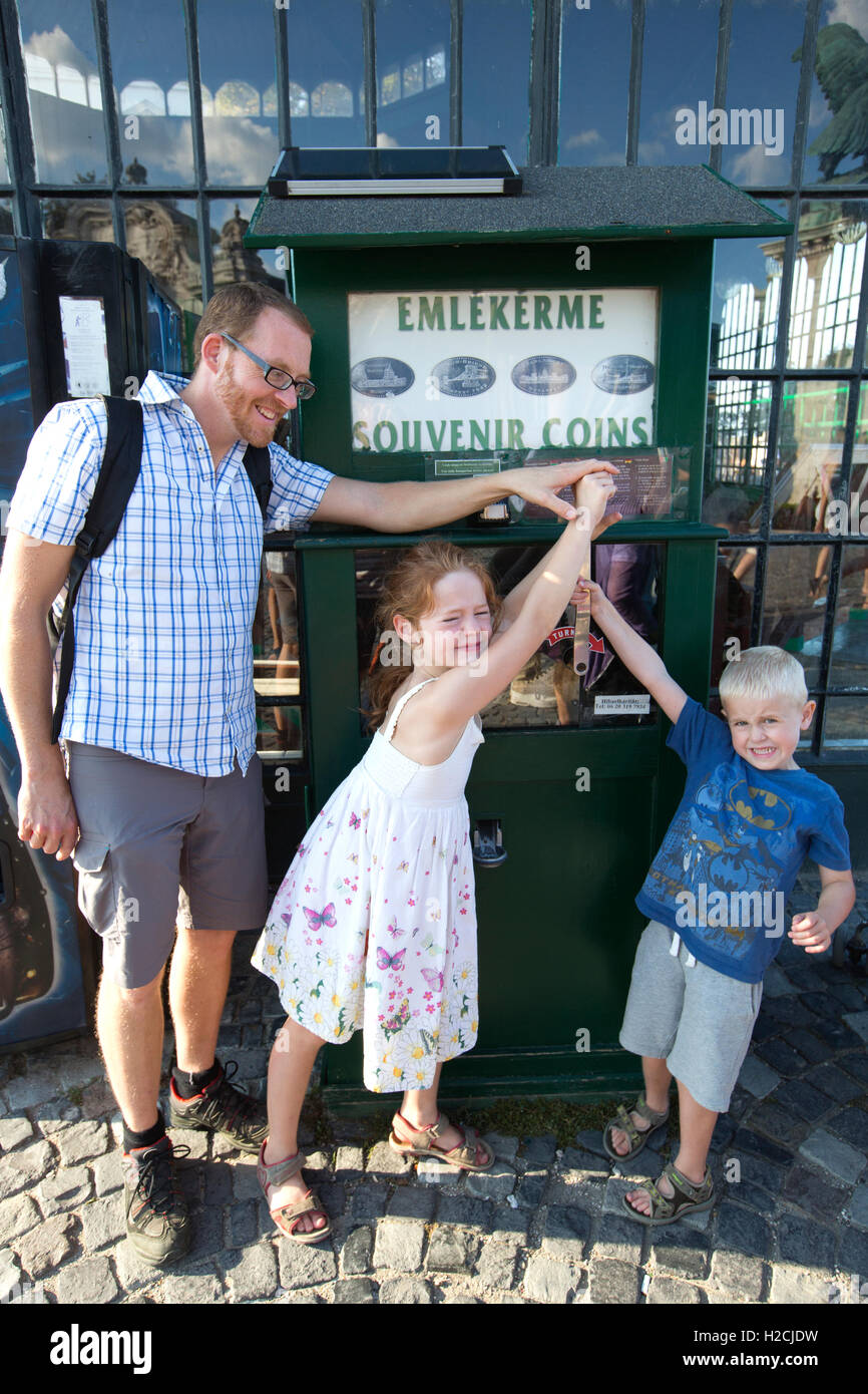 Famiglia rendendo le monete di souvenir al di fuori della funicolare tram treno, Castello di Buda, Budapest, Ungheria, Europa Foto Stock