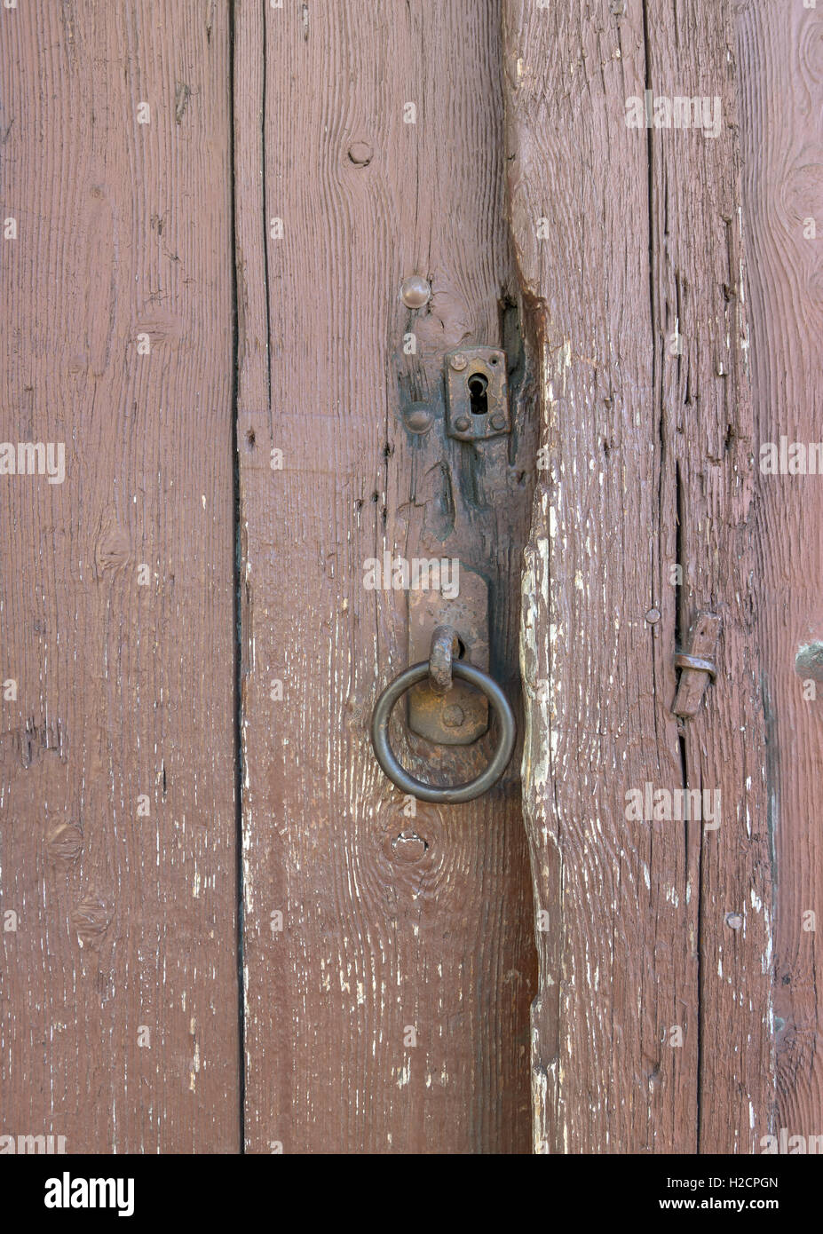 Anello di metallo e bloccare su un vecchio, marrone, weathered porta in legno Foto Stock