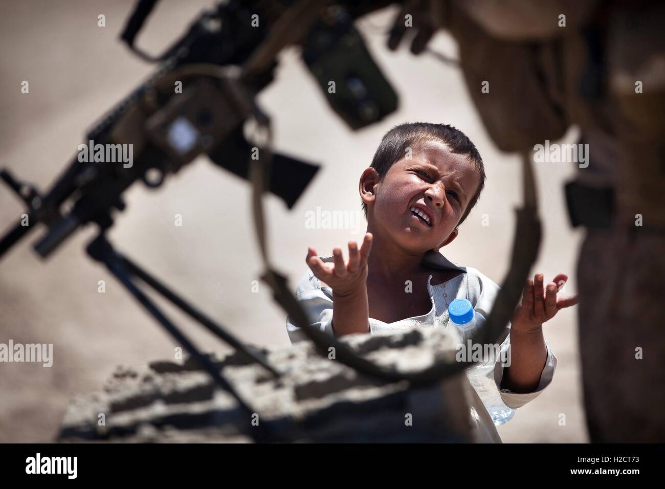 Un ragazzo afghano mendica un U.S. Marine durante una pattuglia di sicurezza Aprile 28, 2012 in Safar, Garmsir distretto, Afghanistan. Foto Stock