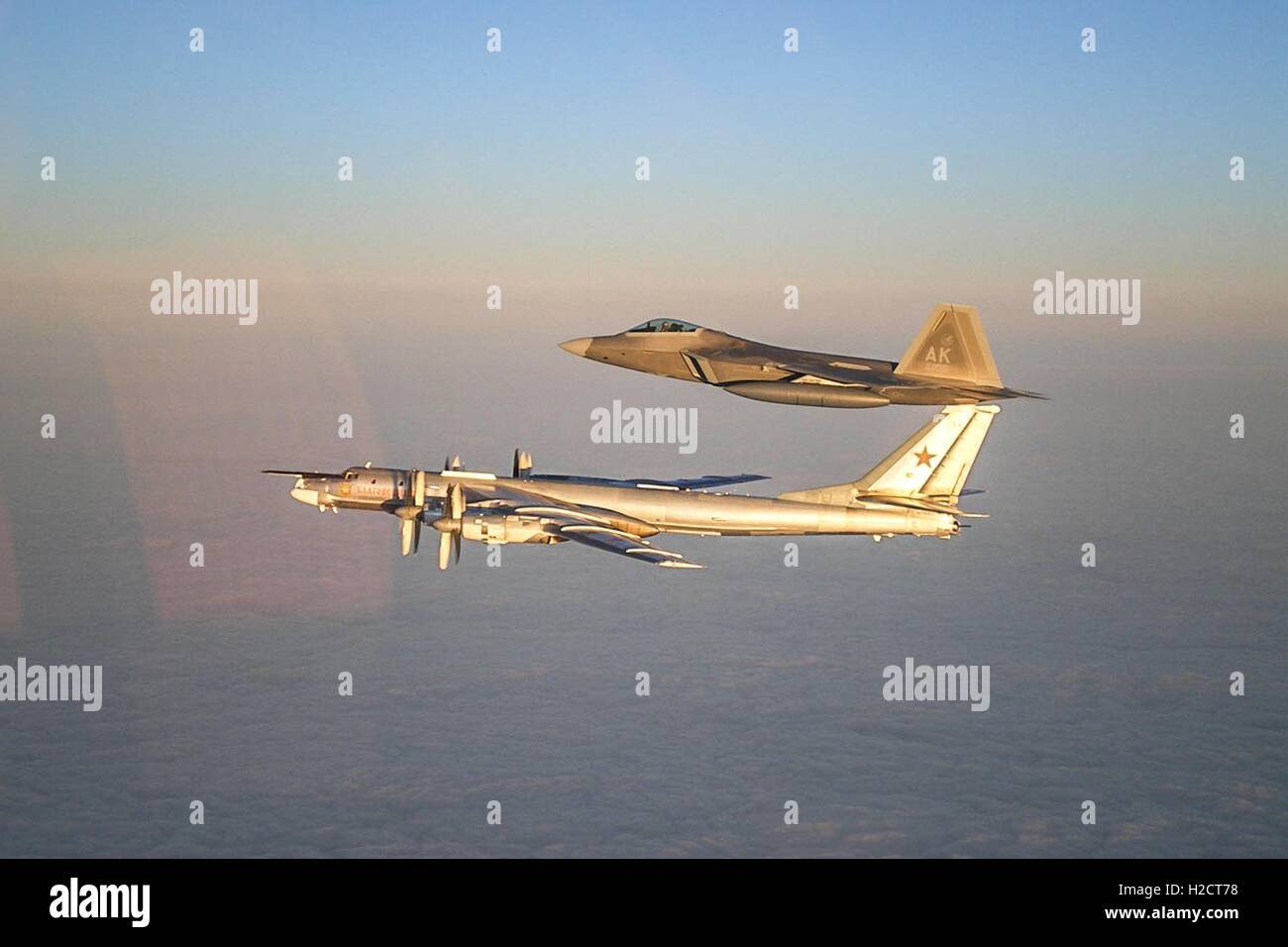 Un U.S. Air Force F Raptor stealth Tactical Fighter Aircraft accompagnatrici un russo TU-95 Orso bombardiere strategico in volo Novembre 22, 2007 vicino all'Alaskan NORAD regione dello spazio aereo. Foto Stock