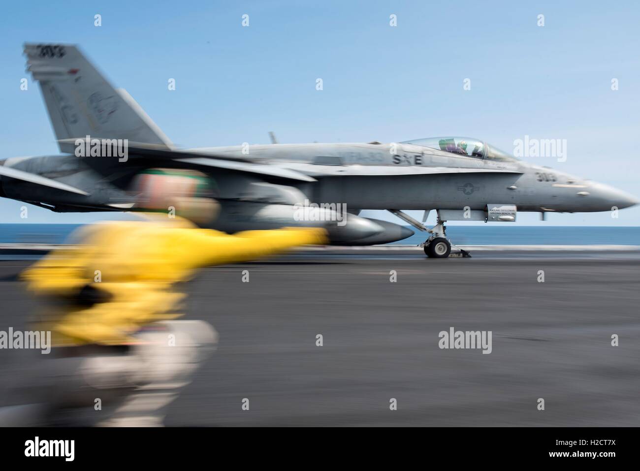 Un U.S. Marina ponte di volo equipaggio officer segnali per il decollo come F/A-18C Hornet jet lancia dal ponte di volo dell'USN Nimitz-class portaerei USS Harry Truman Luglio 12, 2016 nell'Oceano Atlantico. Foto Stock