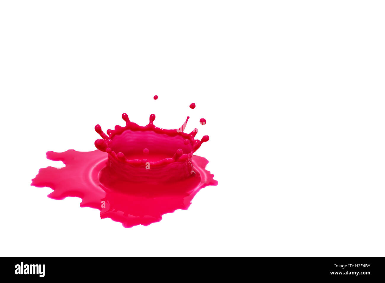 Colore rosso spruzzi di acqua su un isolato la superficie bianca. Spazio libero per il tuo testo è nel lato destro della foto. Foto Stock
