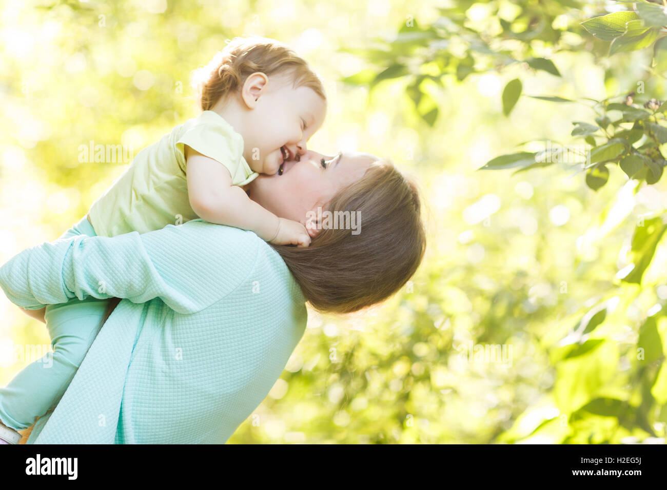 Giovane madre trattiene bambina in posizione di parcheggio Foto Stock