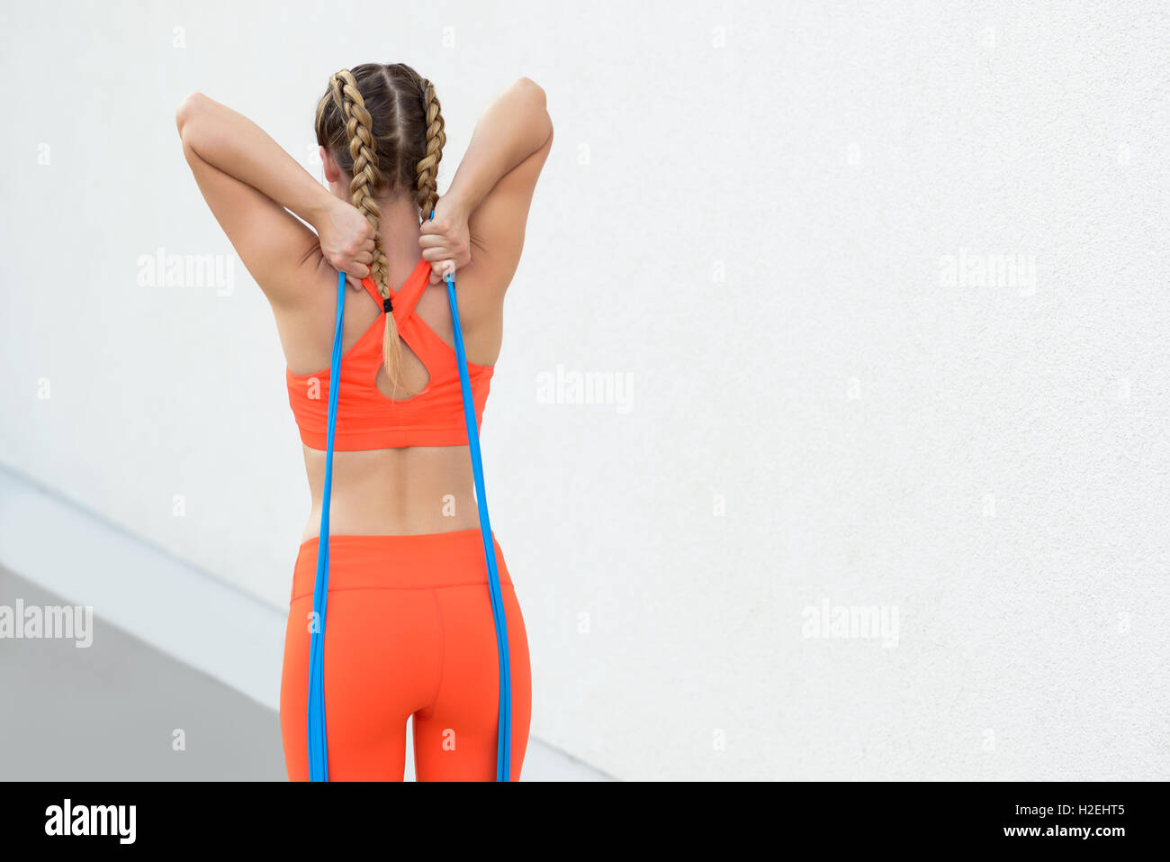 Giovane donna sportivo facendo core Rafforzare esercitazioni utilizzando bande di lattice in una salute e stile di vita concetto, vista sul retro tenere premuto Foto Stock