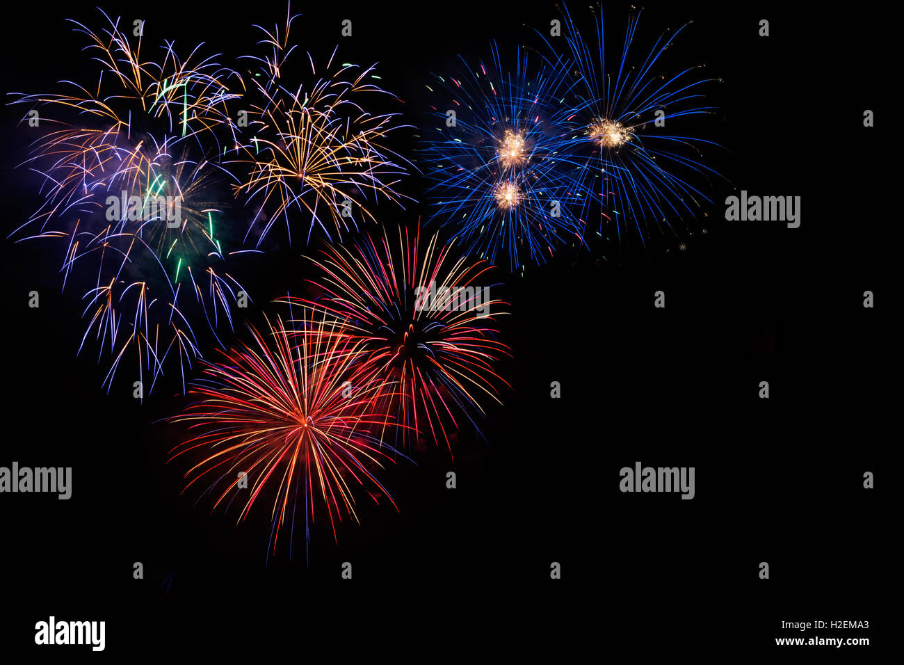 Celebrazione bella colorata di rosso blu dorato fuochi d'artificio, salutate con display di abbagliamento nel cielo notturno sfondo. Un incendio di grandi dimensioni Foto Stock