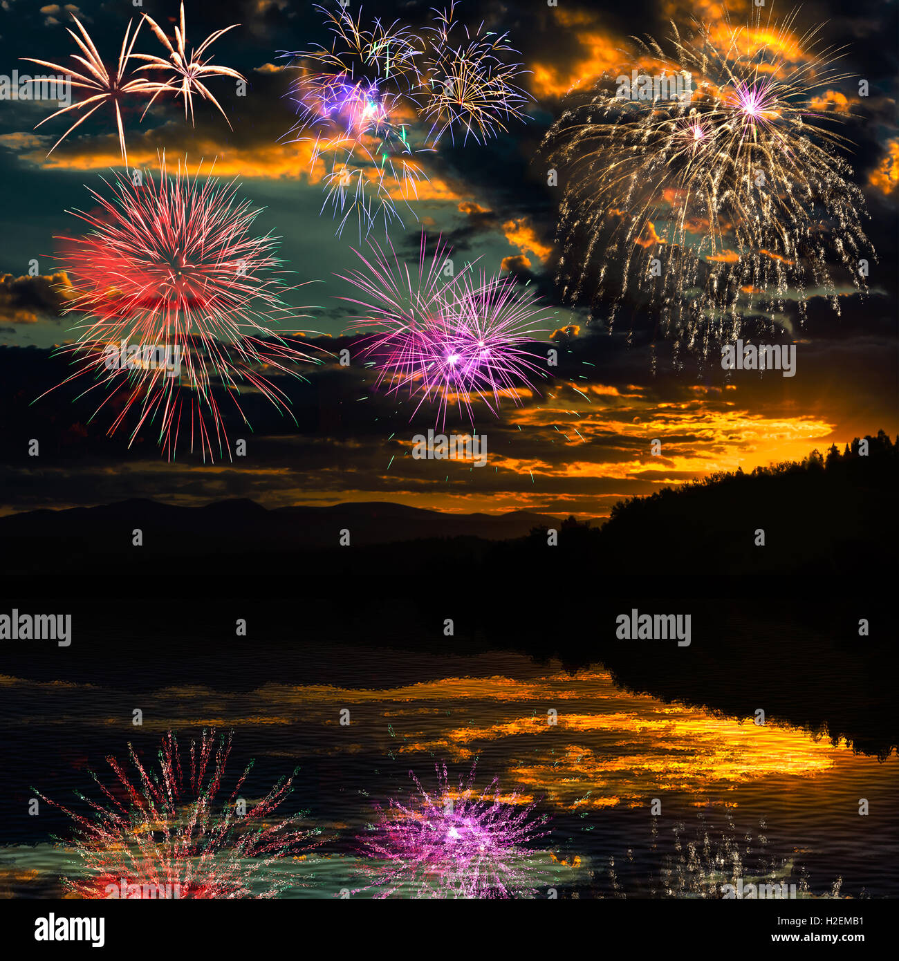 Multicolor bella celebrazione incredibili fuochi d'artificio, salutate con display di abbagliamento nel Cielo di tramonto sfondo, riflessa nella Foto Stock