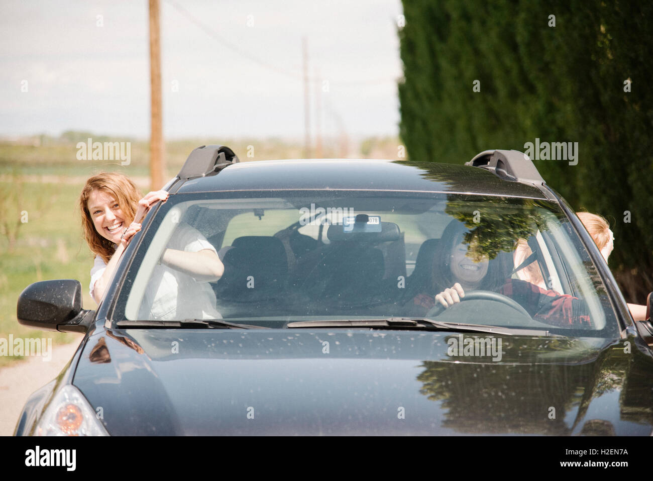 Due donne inclinazione verso l'esterno di una macchina windows. Foto Stock