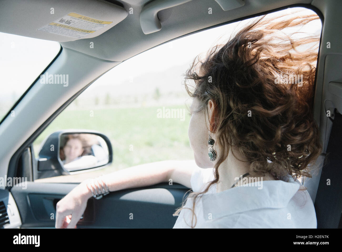 La donna in una vettura in un viaggio su strada, guardando fuori della finestra. Foto Stock