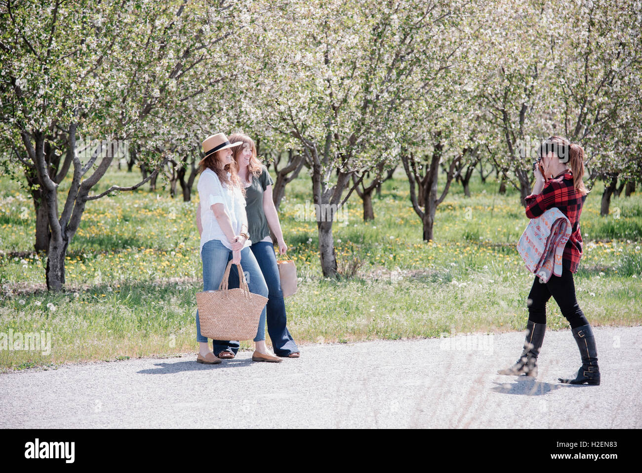 Un fotografo a scattare foto di due donne su un giorno d'estate. Foto Stock