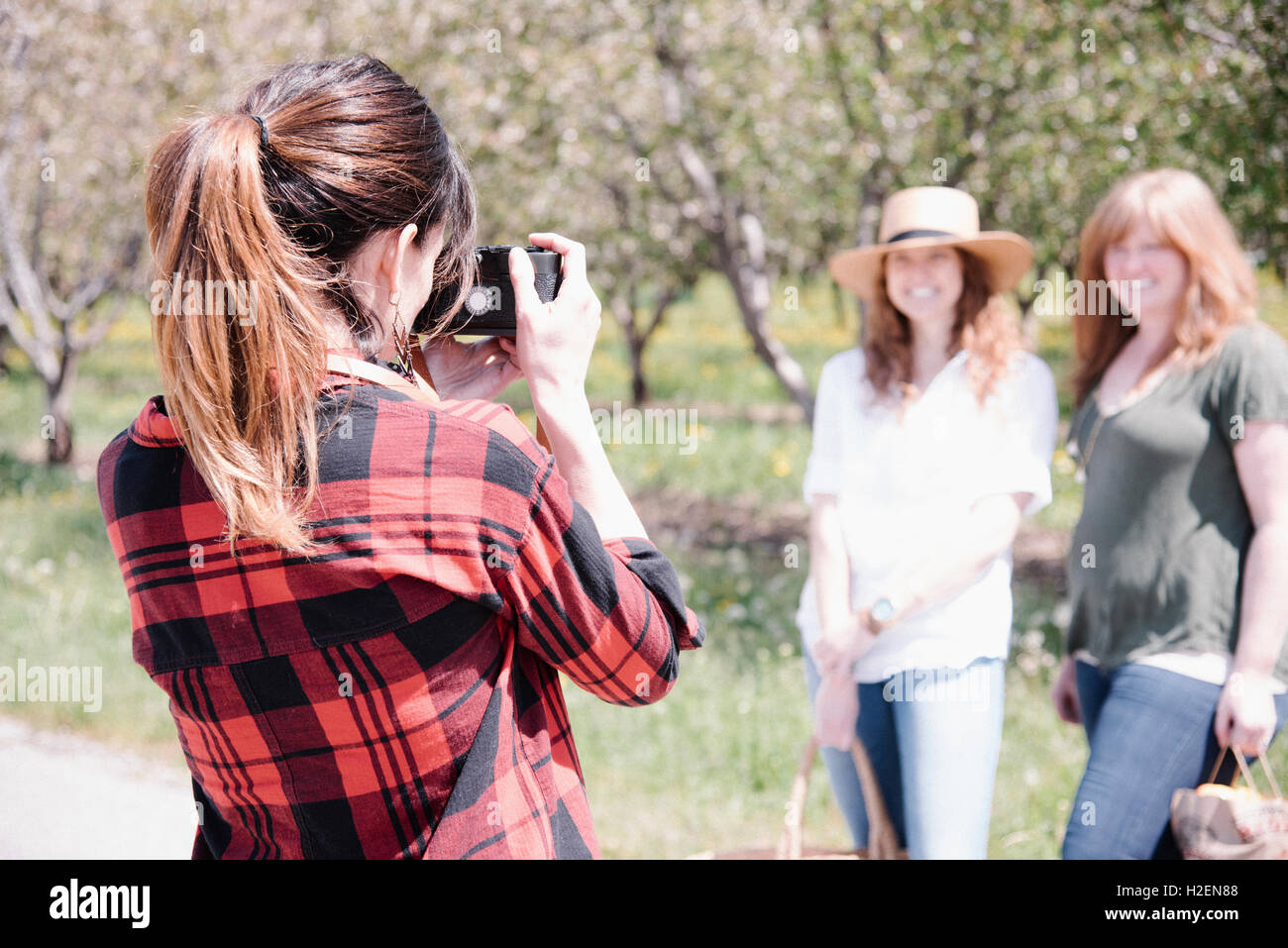 Un fotografo a scattare foto di due donne su un giorno d'estate. Foto Stock