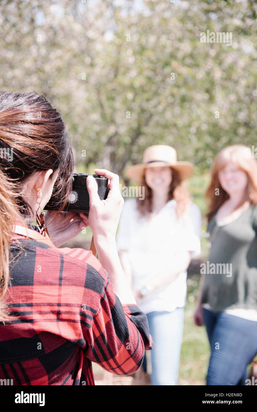 Un fotografo a scattare foto di due donne su un giorno d'estate. Foto Stock