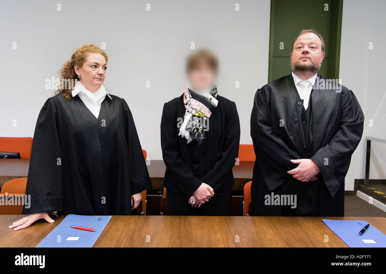 Monaco di Baviera, Germania. 28 ott 2016. La convenuta, ostetrica Regina K. (C), sul processo per tentato omicidio attraverso la manipolazione durante il parto, sorge tra i suoi avvocati Hermann Christoph Kuehn e Daniela è salito all'inizio della prova nella Corte Regionale di Monaco di Baviera, Germania, il 28 ottobre 2016. Secondo l'accusa, la 35-anno-vecchio ostetrica assertivamente diede i pazienti nel Monaco di Baviera Grosshadern hospital e Bad Soden più sottile di sangue prima di C-sezione nascite nel tentativo di uccidere le donne. Foto: Matthias esitano di fronte/dpa (Defendent disturbato dalla richiesta dei suoi avvocati)/dpa/Alamy Live News Foto Stock