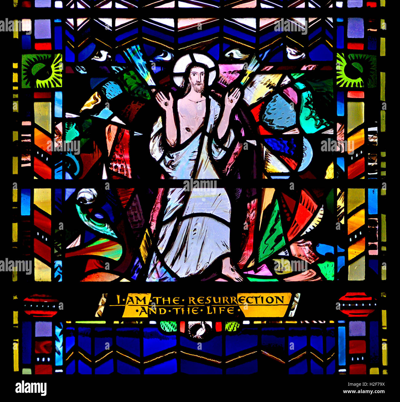 Londra, Inghilterra, Regno Unito. St Etheldreda la Chiesa in Ely Place. Finestra di vetro colorato: Giovanni 11:25 "Io sono la risurrezione e la vita" Foto Stock