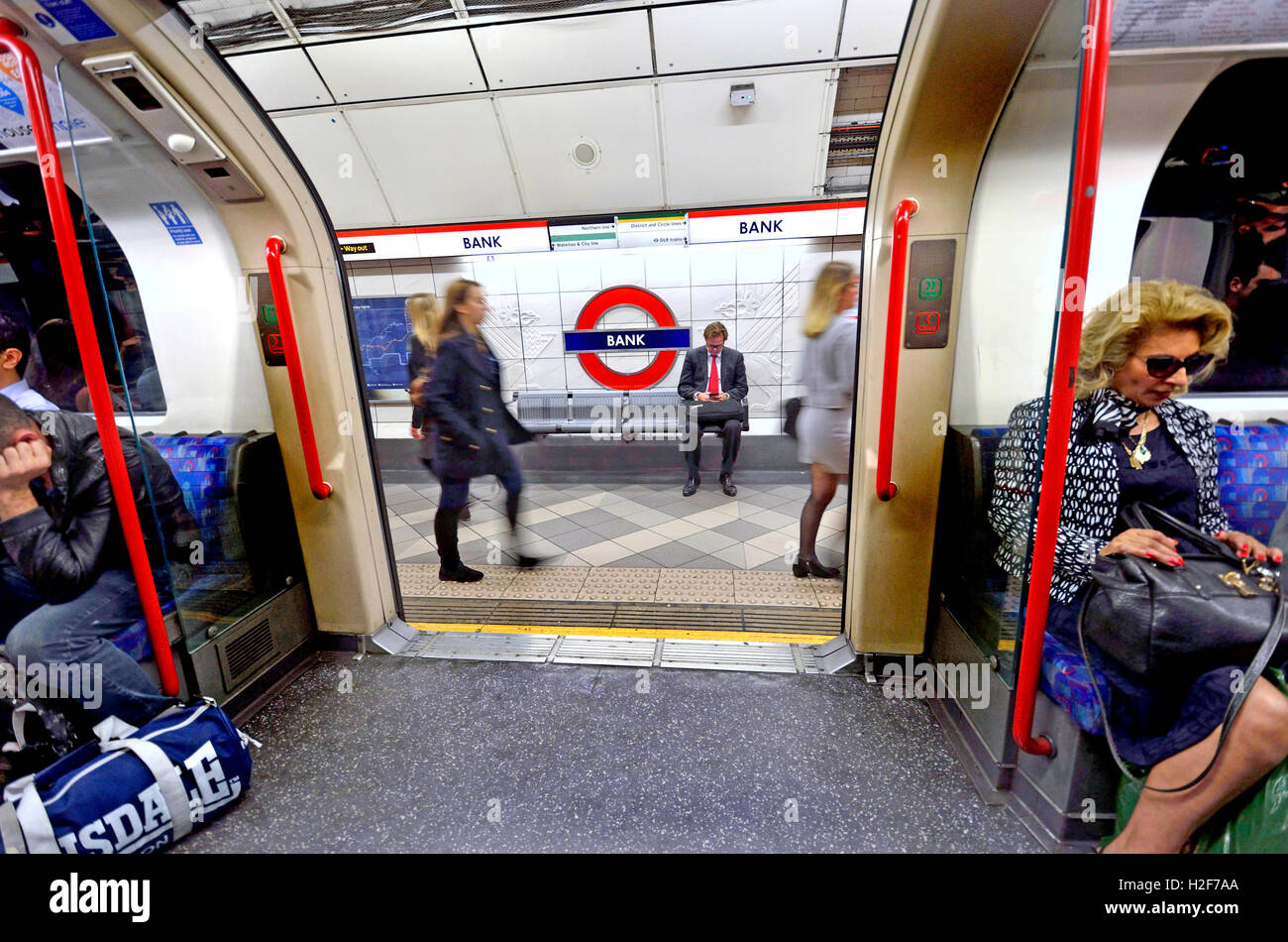 Londra, Inghilterra, Regno Unito. La metropolitana di Londra la stazione della metropolitana: stazione porte aperte presso la banca station - imprenditore sulla lettura della piattaforma Foto Stock