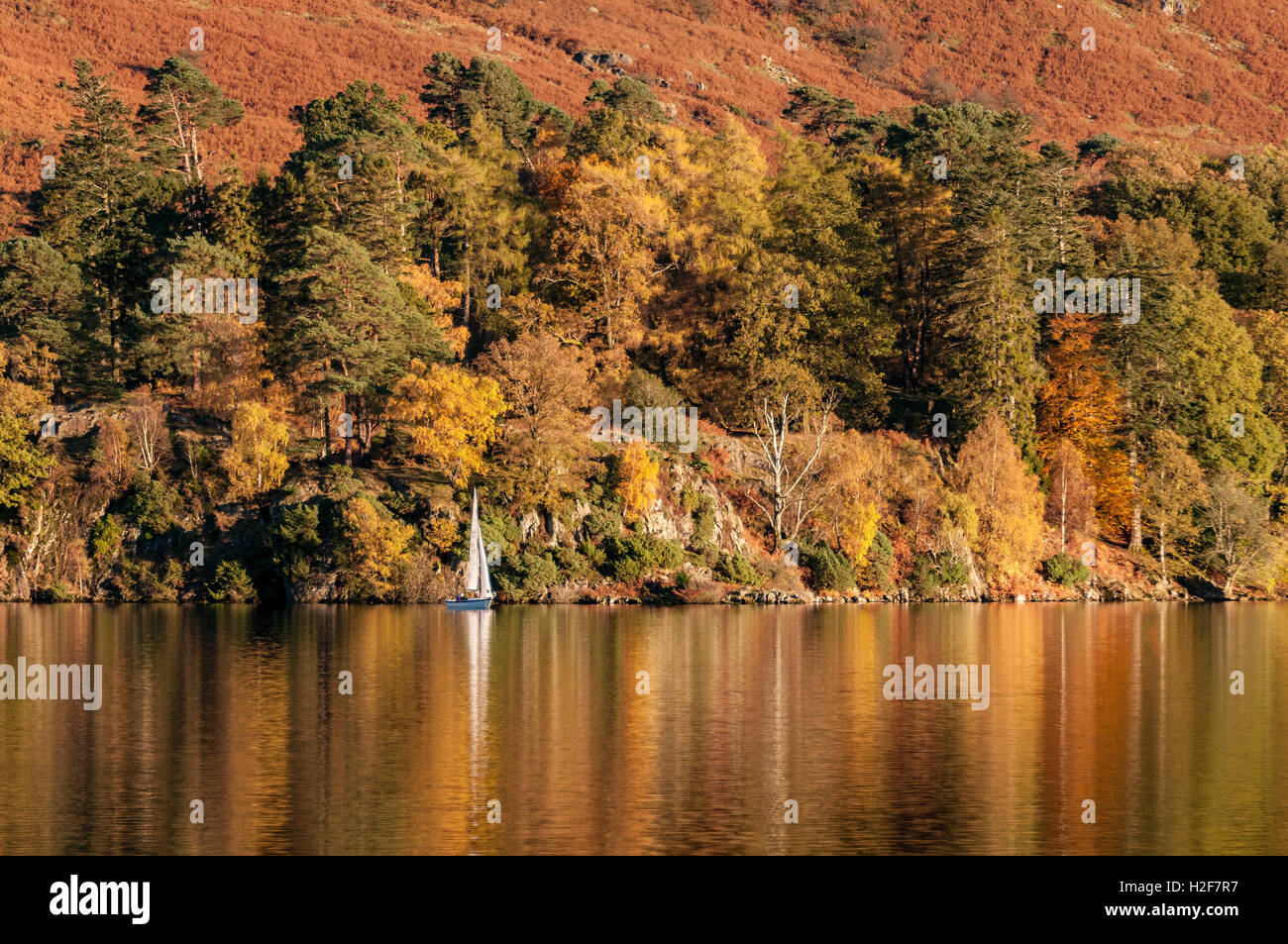 Una solitaria yacht in i colori dell'autunno sul lago Ullswater. Parco Nazionale del Distretto dei Laghi. Cumbria North West England. Foto Stock