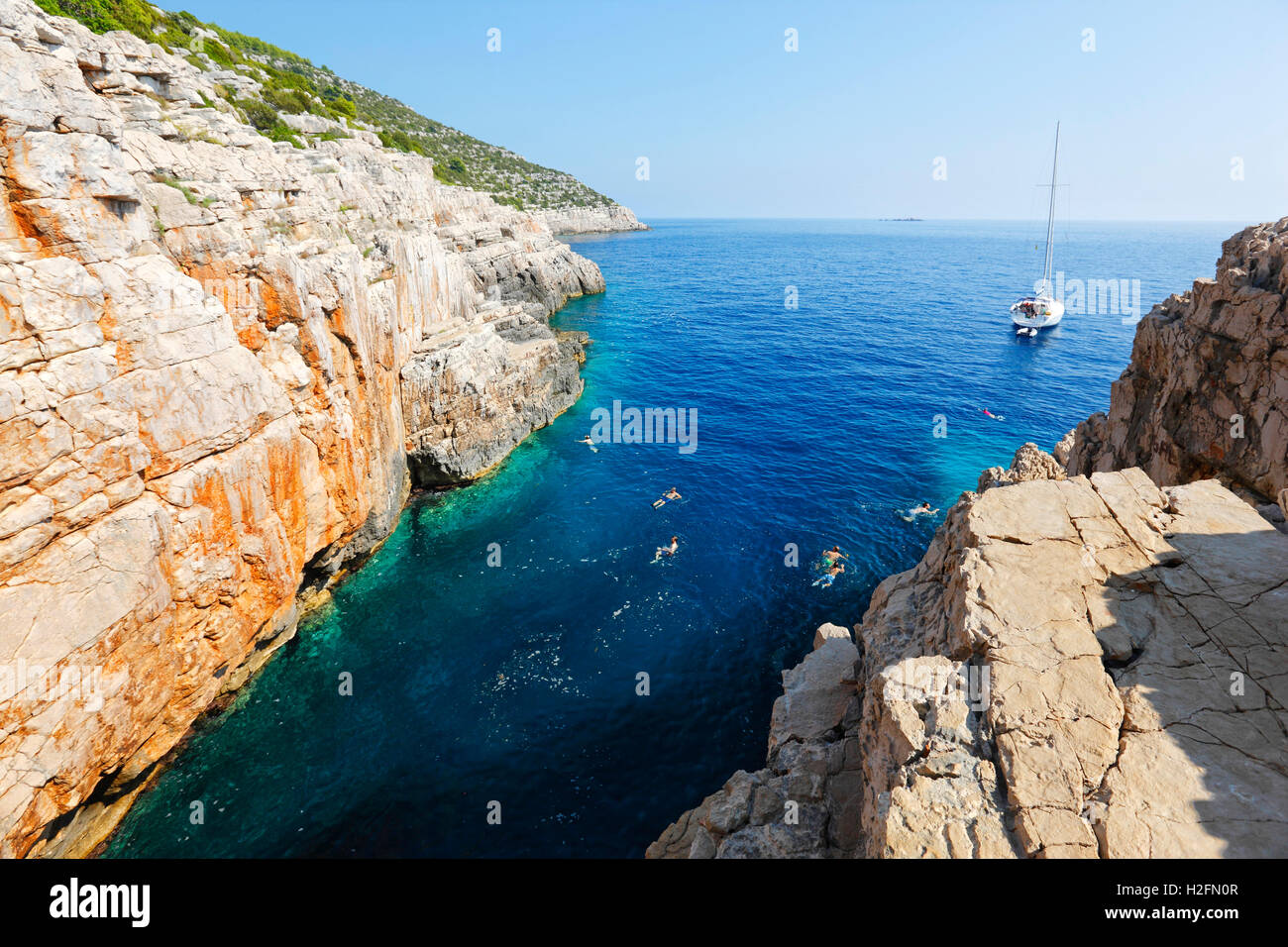 I turisti saltando dal dirupo nel mare su Odisej grotta sul isola di Mljet Foto Stock