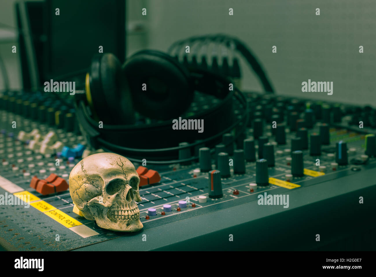 Cranio umano in appoggio su di un mixer audio. Sullo sfondo delle console mixer e cuffie,TONO Vintage Foto Stock