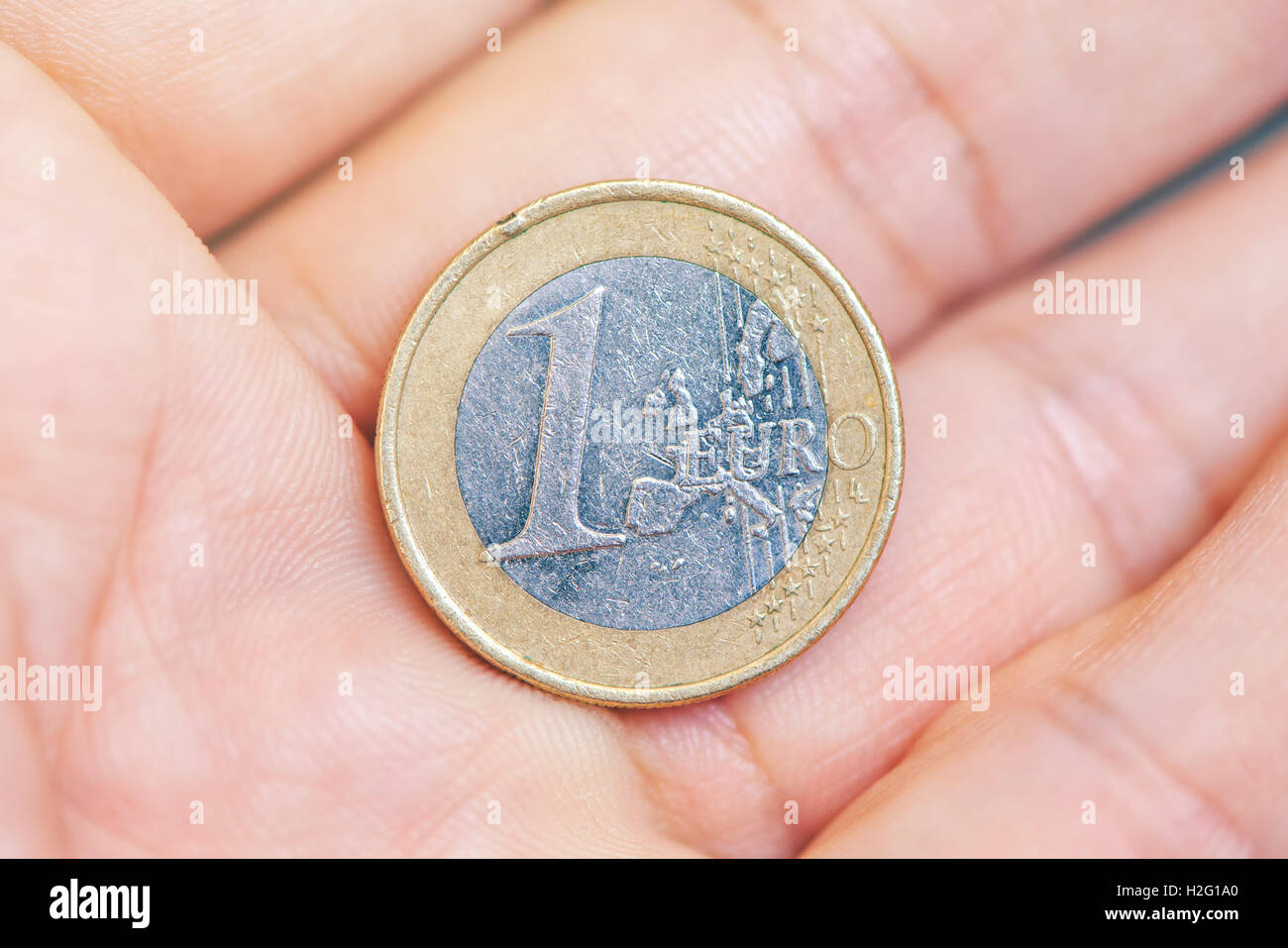 L'uomo che offre un euro moneta sul palmo della mano - business, finanza, economia, finanziamenti, risparmi di denaro o il concetto di donazione. Foto Stock