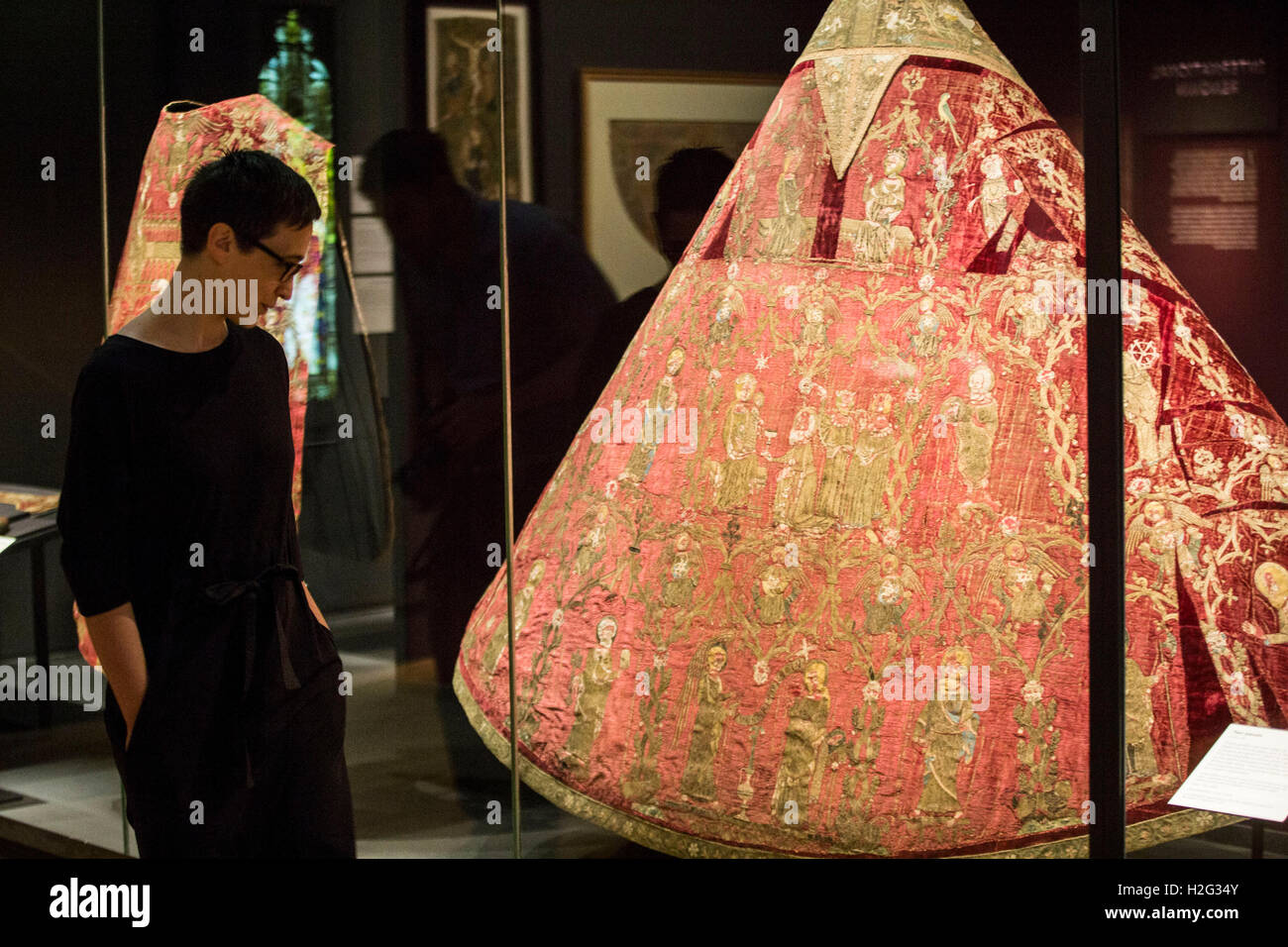 Una donna guarda al Butler-Boden far fronte sul display come parte dell'Opus Anglicanum: Capolavori di Inglese Medievale mostra di ricamo presso il Victoria and Albert Museum (V&A) a Londra. Foto Stock